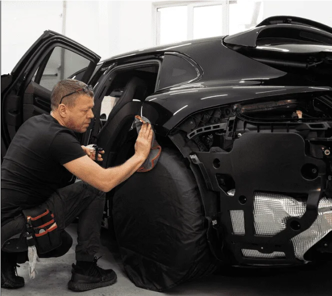 MC Collision technician polishing a car at a Miami paint & body shop for a flawless finish.